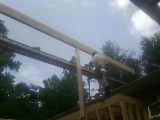 Carpenter setting a ridge beam over a new addition frame — Ice Dam Removal by Roofing Brothers in Braxton