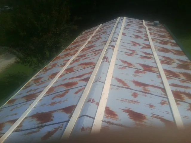 Rusted metal roof panels with new wood purlins before replacement — Storm Damage Roof Repair in Braxton by Roofing Brothers