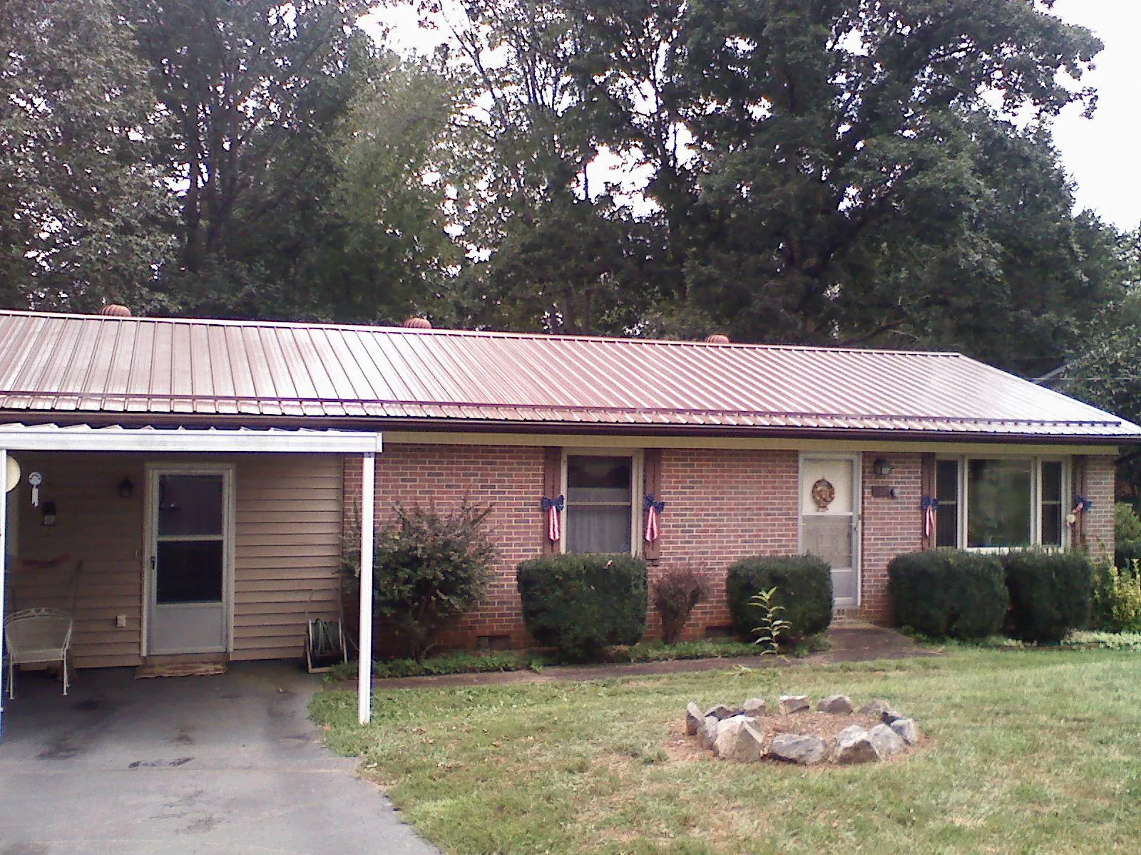 Bronze metal roof and carport on a brick ranch home — Roof Repair work by our crew in Braxton