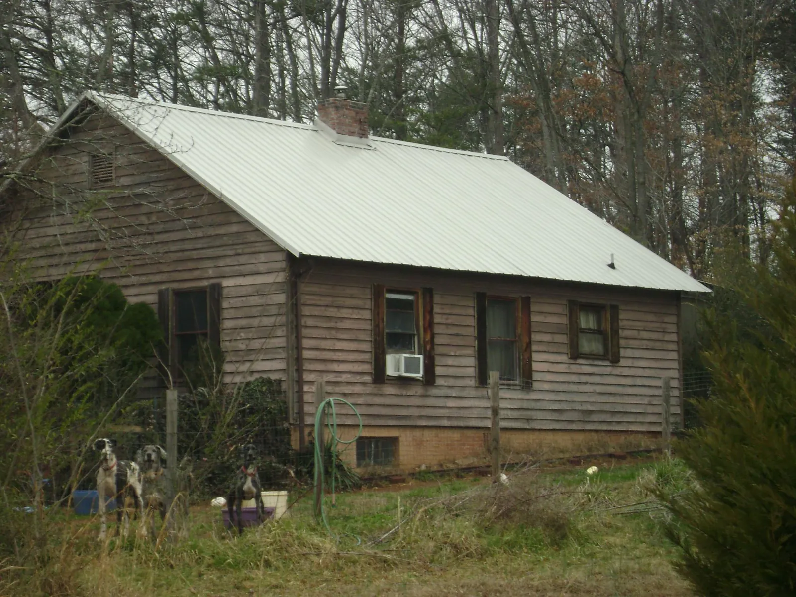 White metal roof on an old wood sided farmhouse, from a Metal Roof Installation job in Braxton